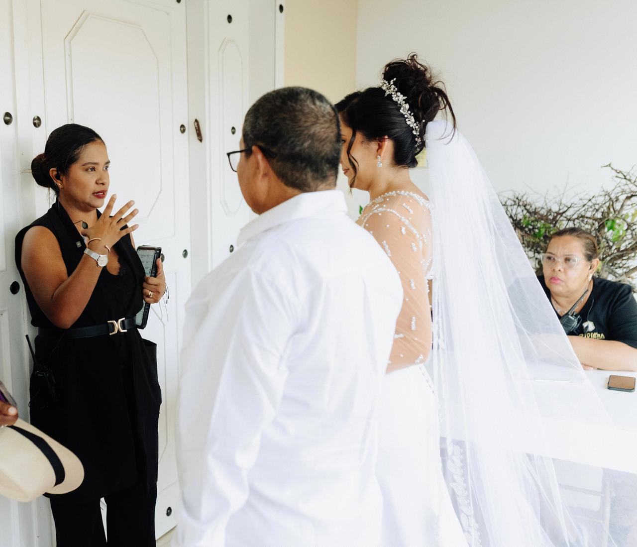 Kelly Saltarin conversando con una novia y su familia durante la preparación del evento.