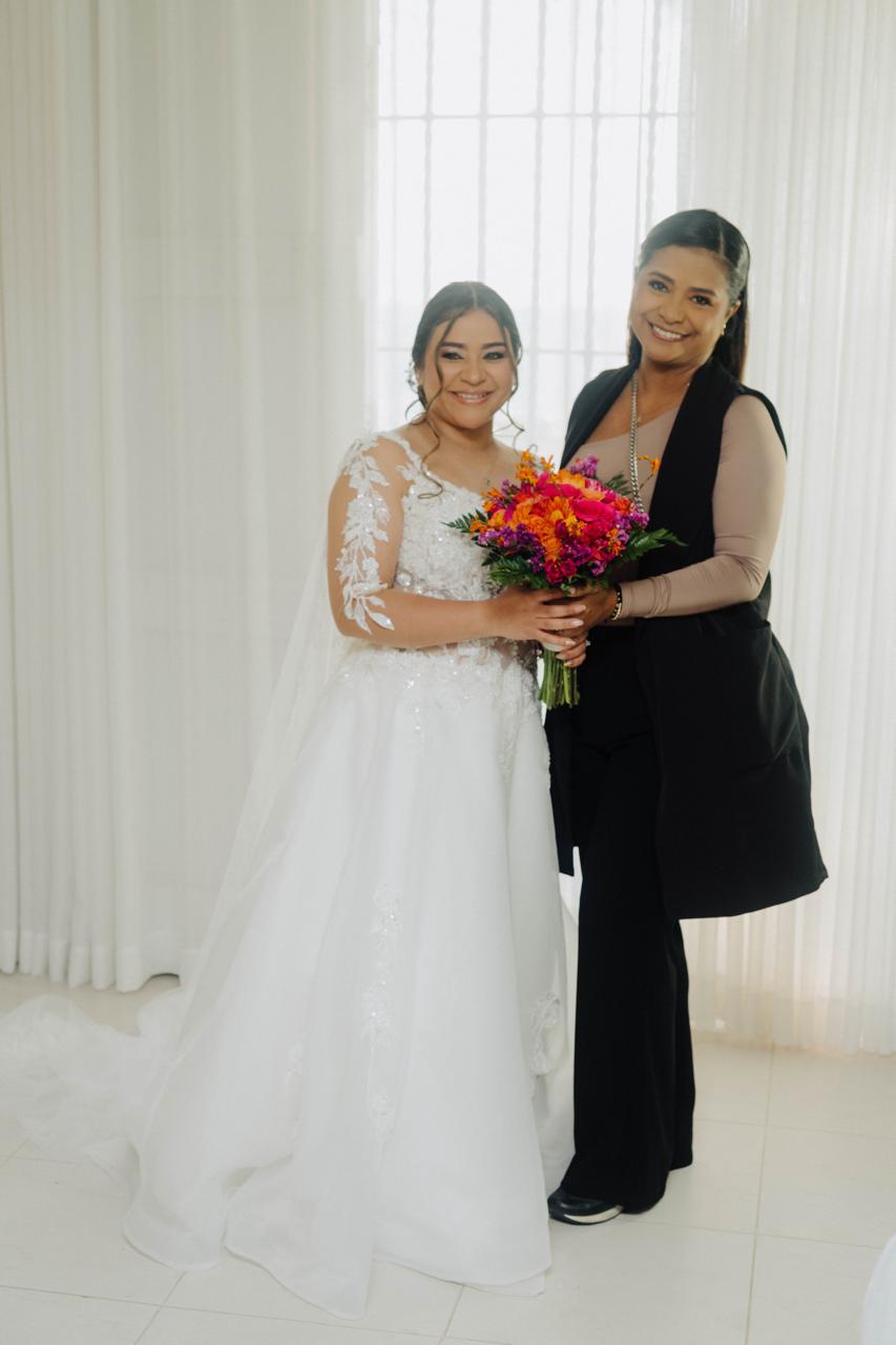 Kelly Saltarin posando junto a una novia con su bouquet antes de la celebración.