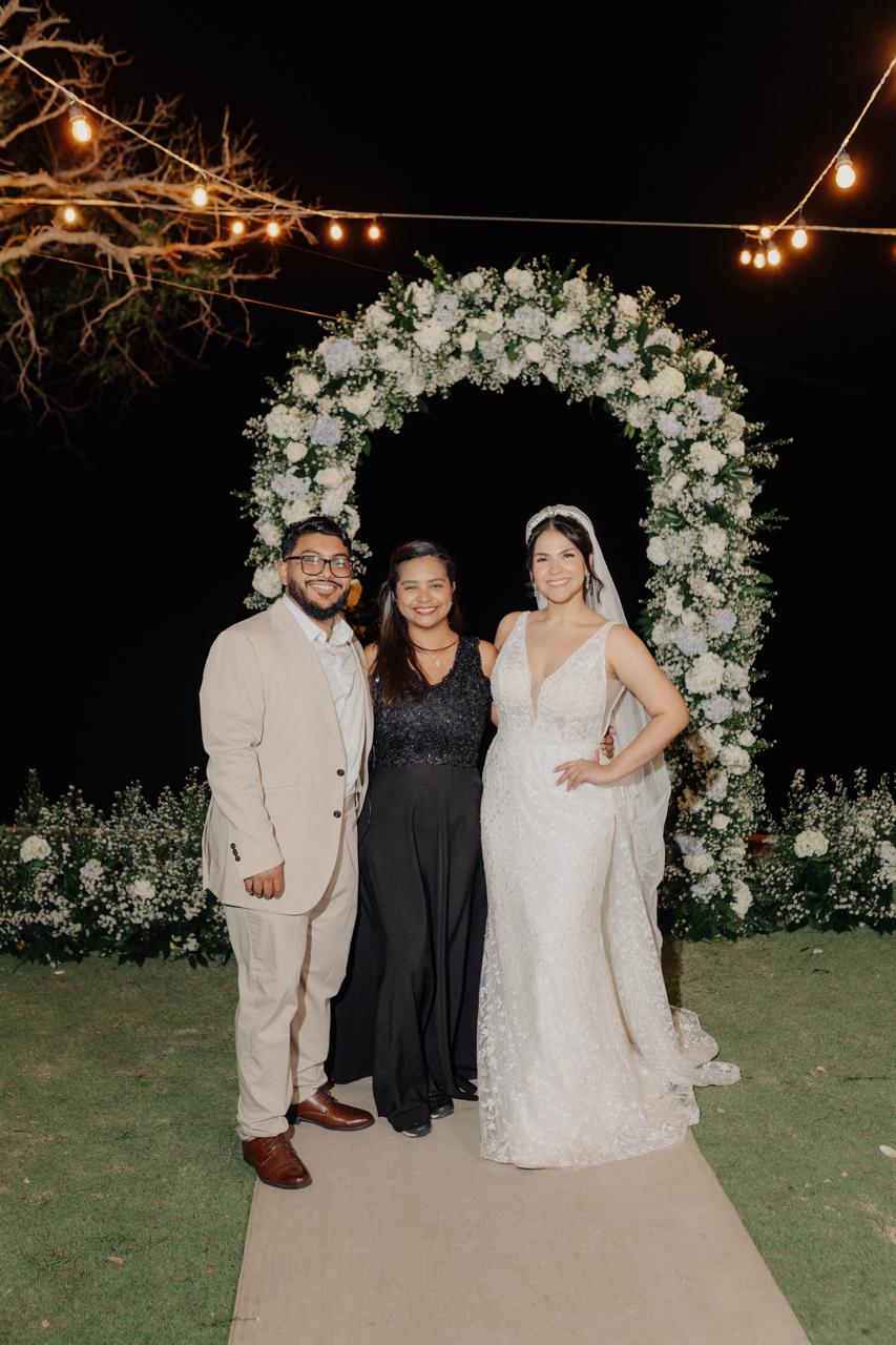 Kelly Saltarin celebrando junto a una pareja recién casada al final de su boda.