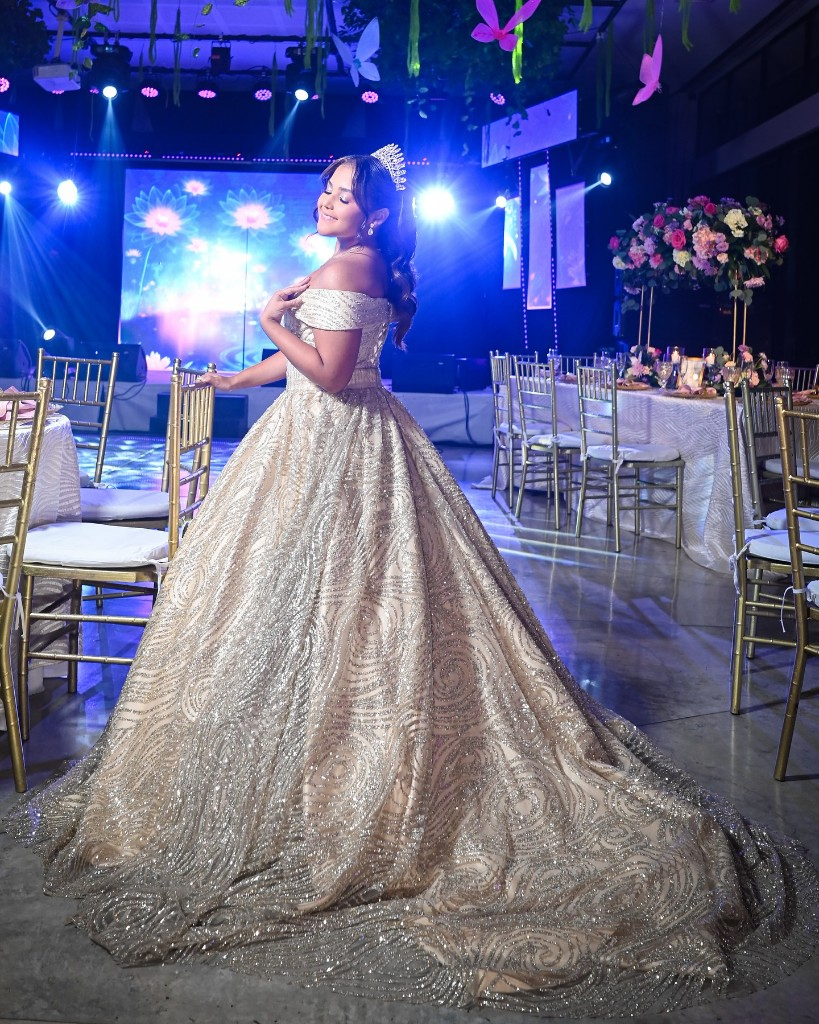Quinceañera en salón dorado en una celebración de quinceañero.
