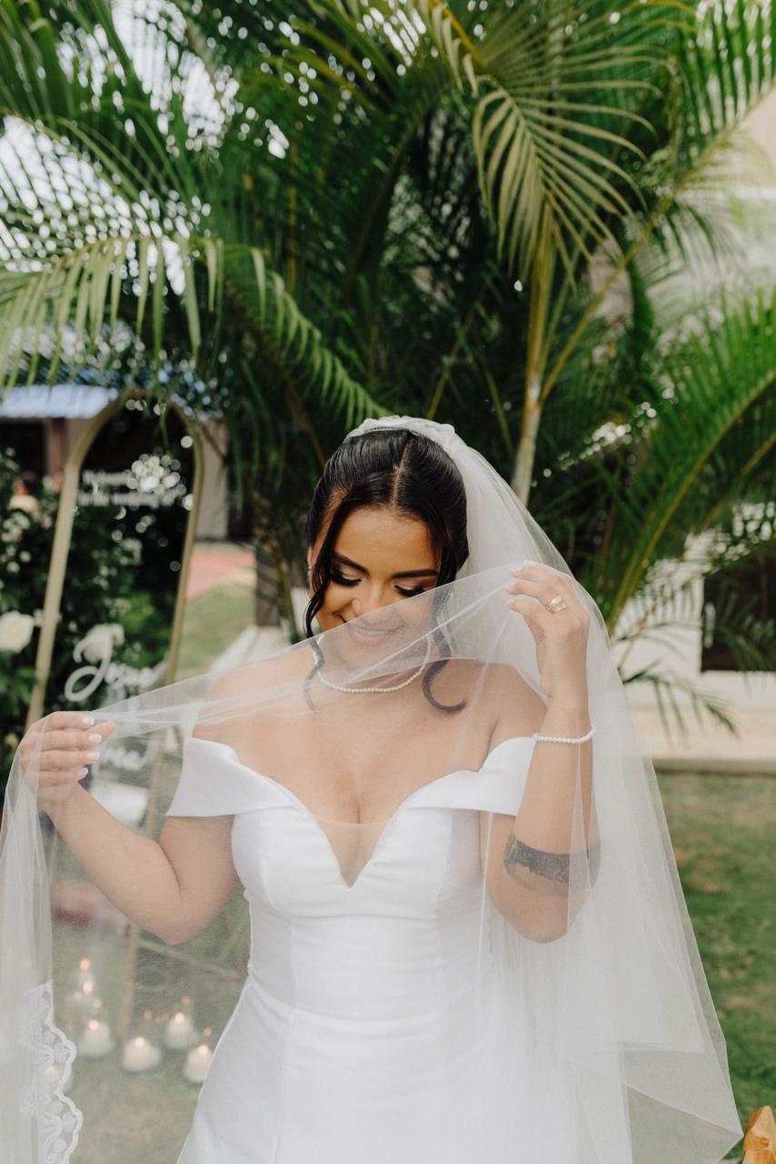 Novia con velo en jardín en una celebración de boda.