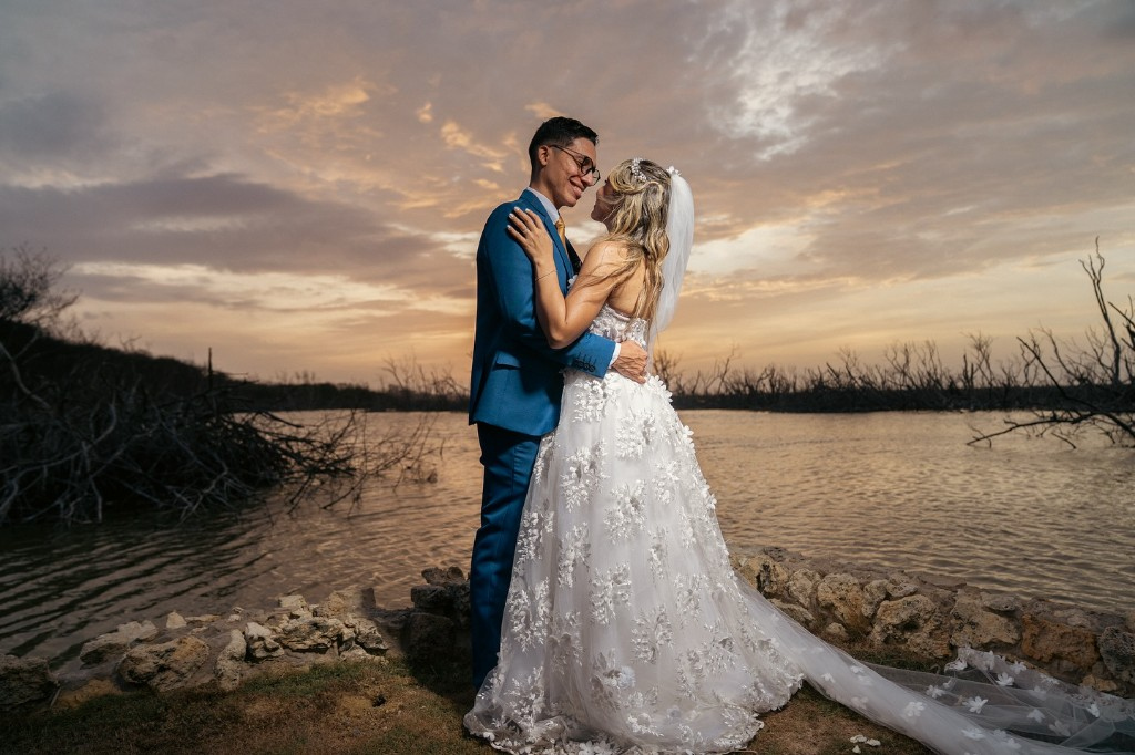 Pareja celebrando su boda en un entorno elegante al atardecer.