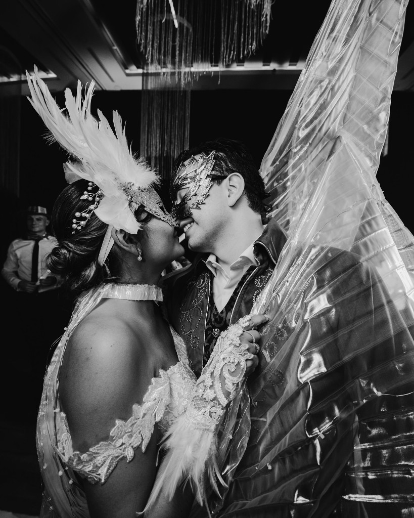Pareja con máscaras de carnaval bailando en la fiesta de boda.